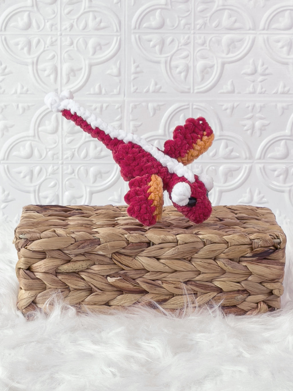Handmade red mini dragon crochet plushie shown from an angled view