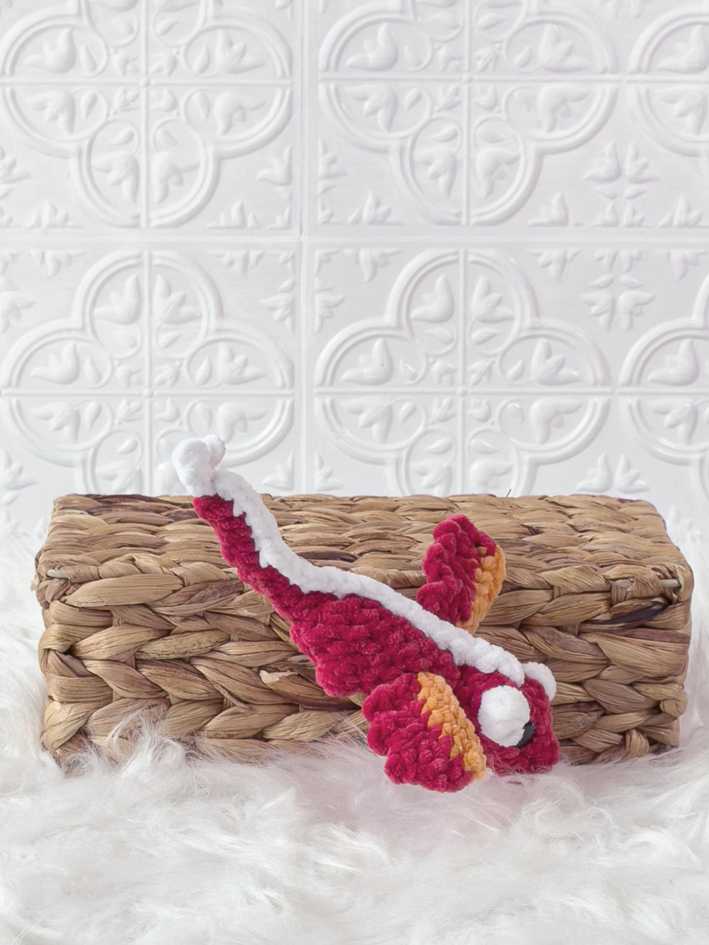 Handmade red mini dragon crochet plushie shown from the side