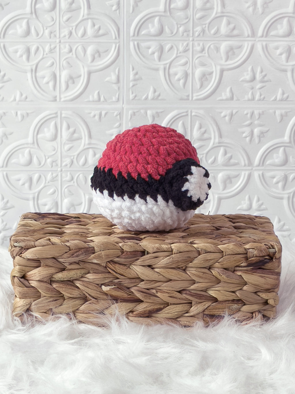 Handmade red poke ball crochet plushie shown from an angled view