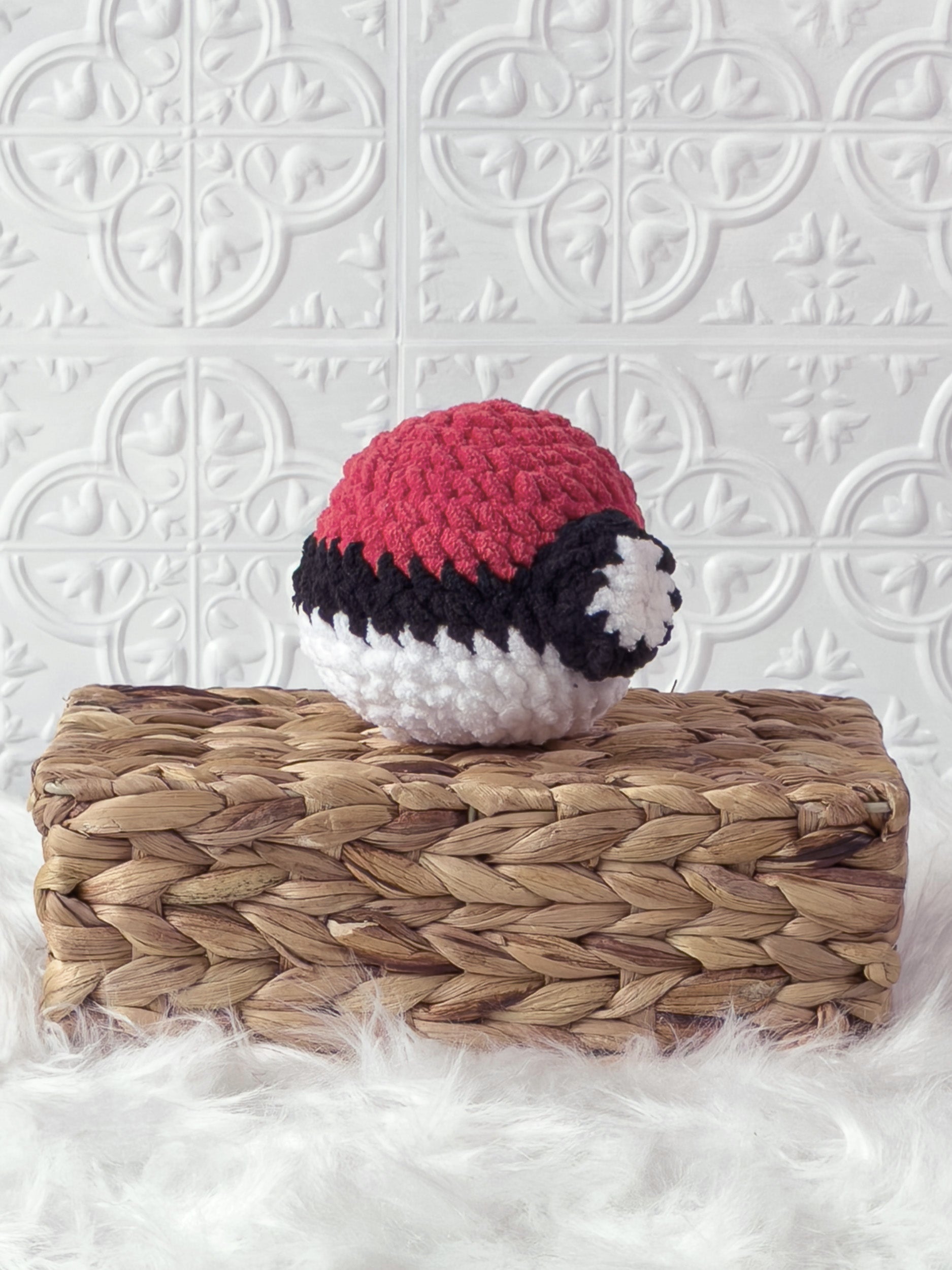 Handmade red poke ball crochet plushie shown from an angled view