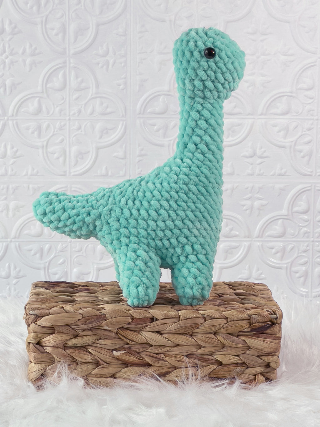 Handmade turquoise brachiosaurus crochet plushie shown from the side
