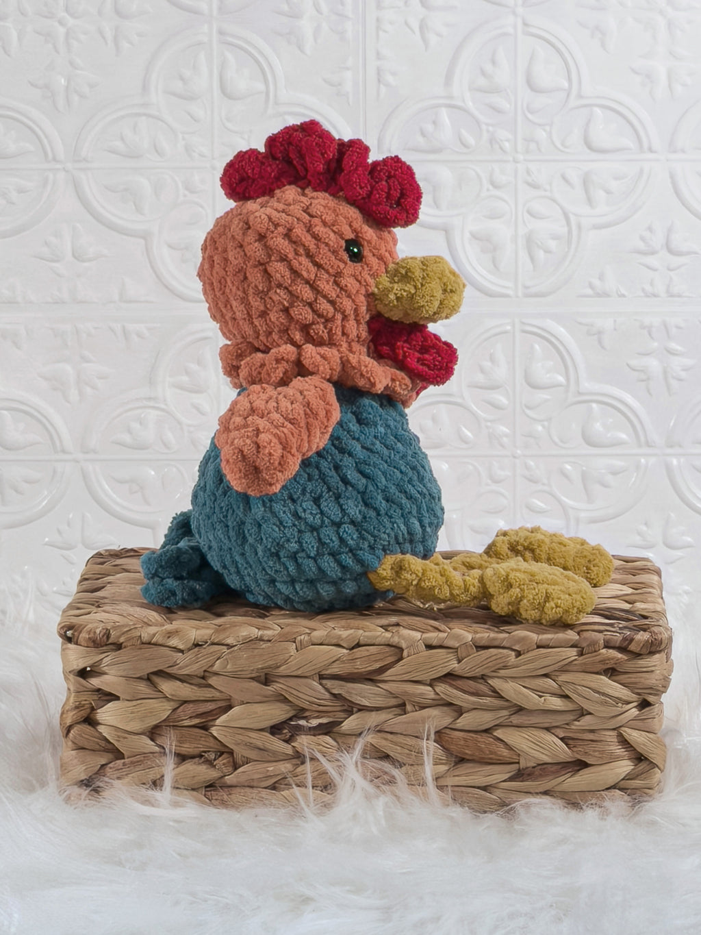 Handmade turquoise sitting rooster crochet plushie shown from the side
