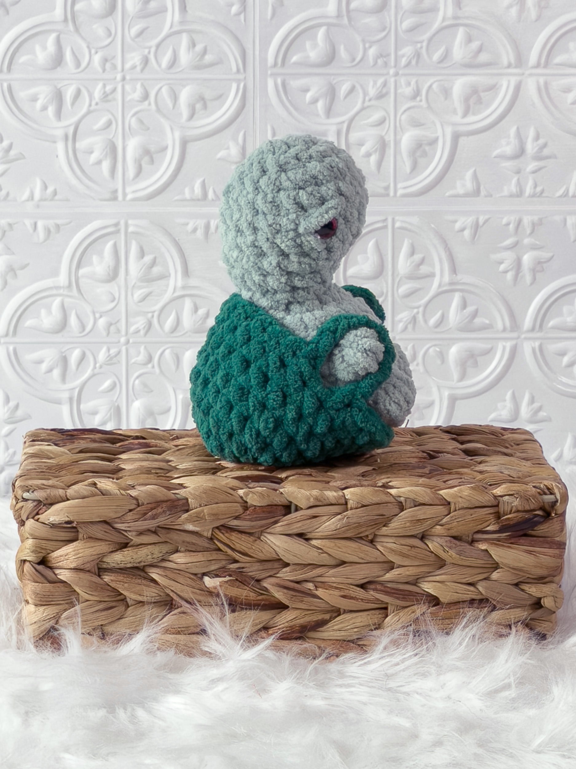 Handmade turquoise, dark turtle crochet plushie shown from the back