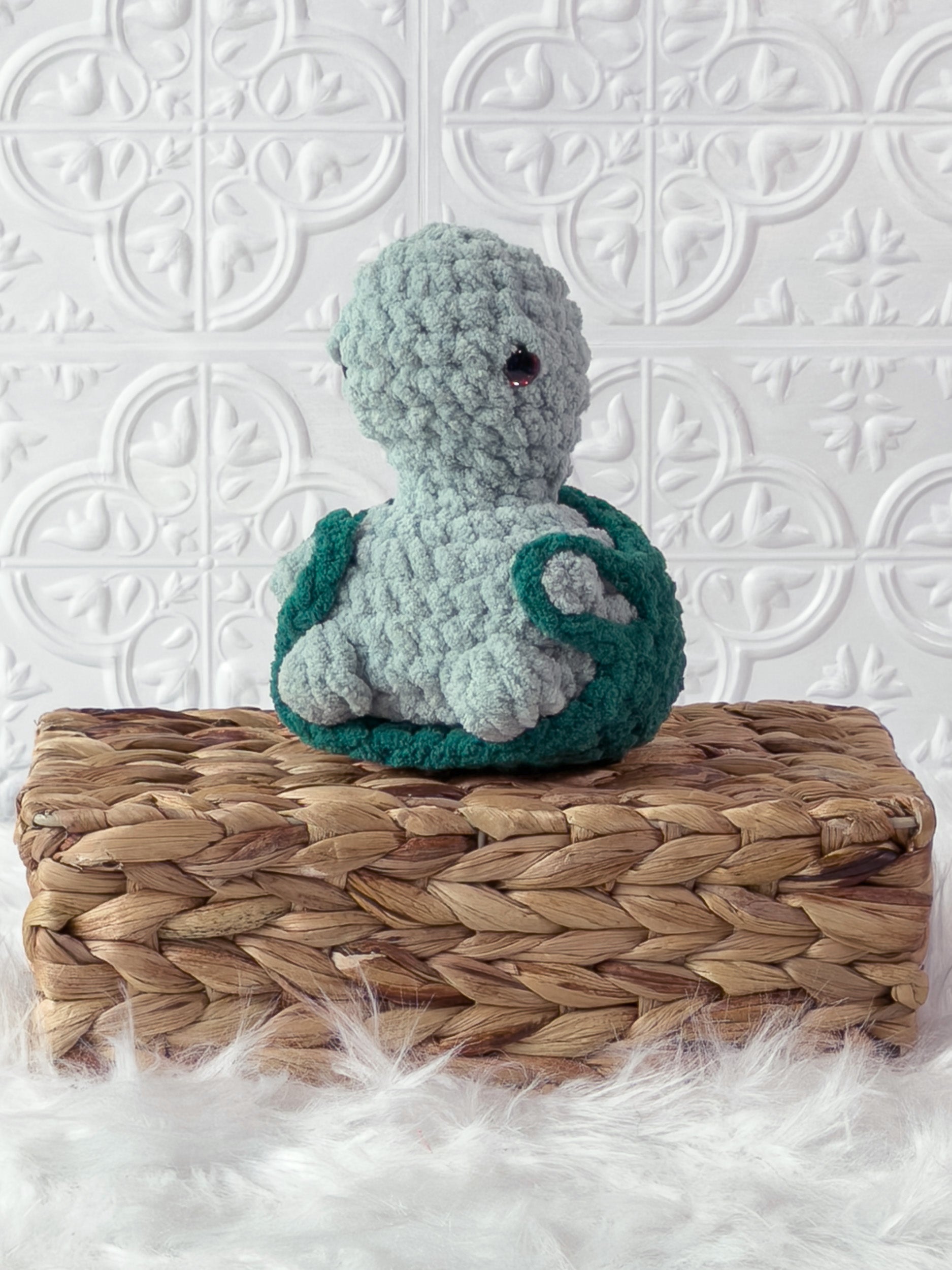 Handmade turquoise, dark turtle crochet plushie shown from the front