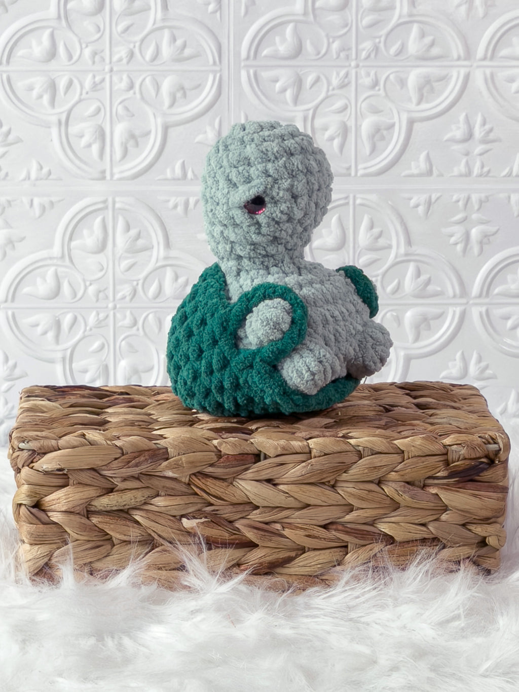 Handmade turquoise, dark turtle crochet plushie shown from the side