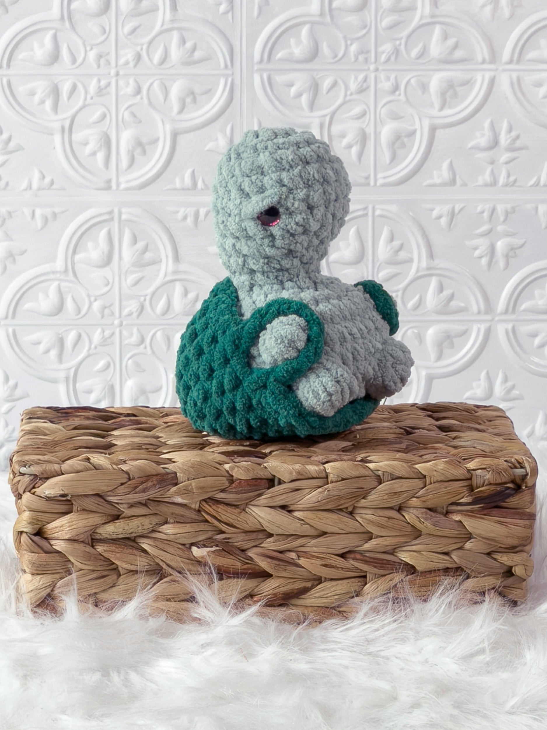 Handmade turquoise, dark turtle crochet plushie shown from the side
