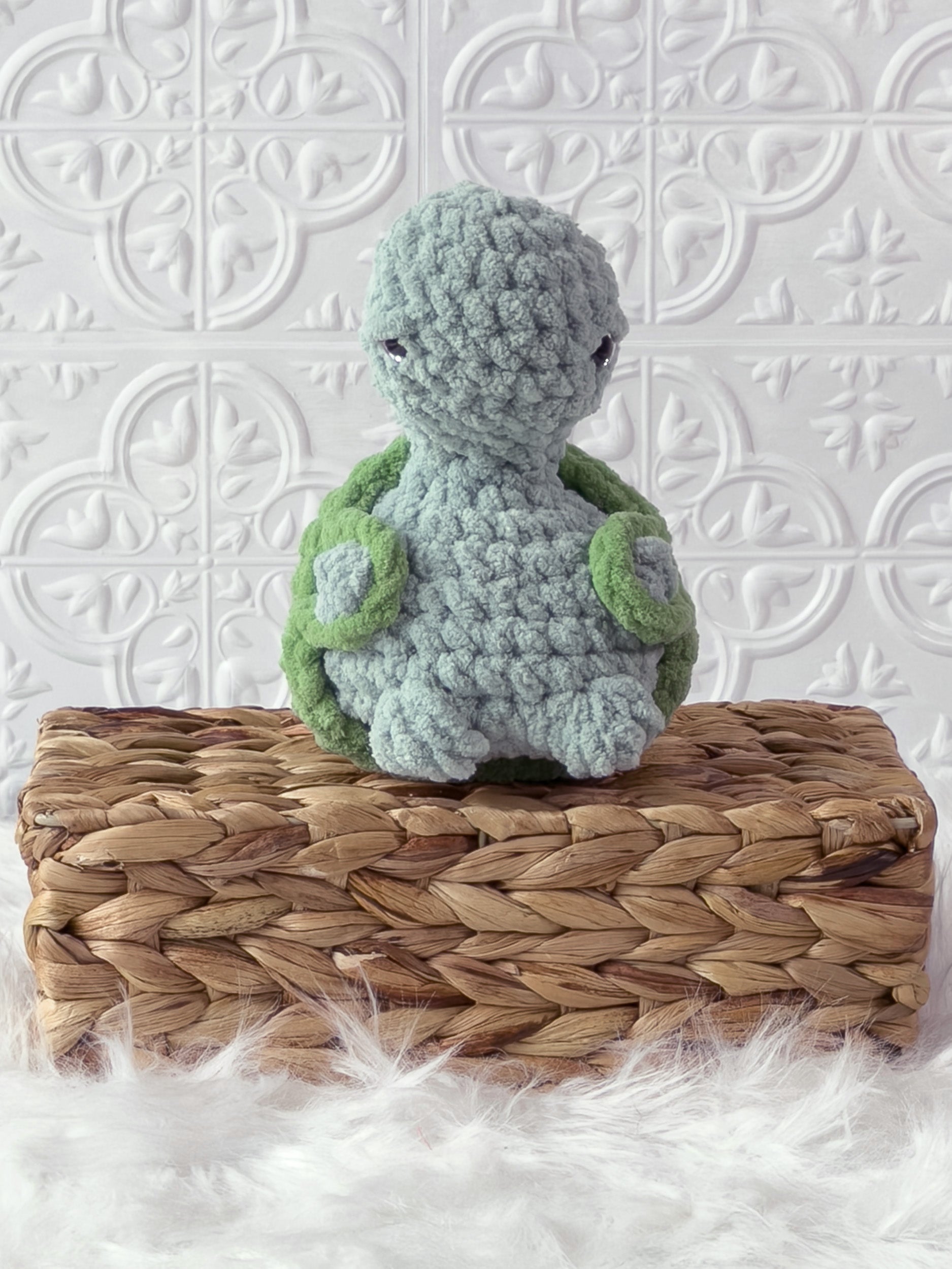 Handmade turquoise, light turtle crochet plushie shown from an angled view