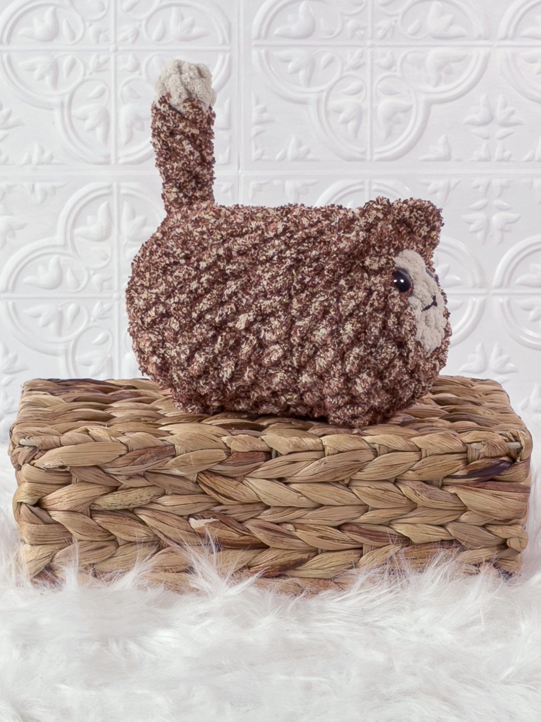Handmade tweed, brown loaf cat crochet plushie shown from an angled view