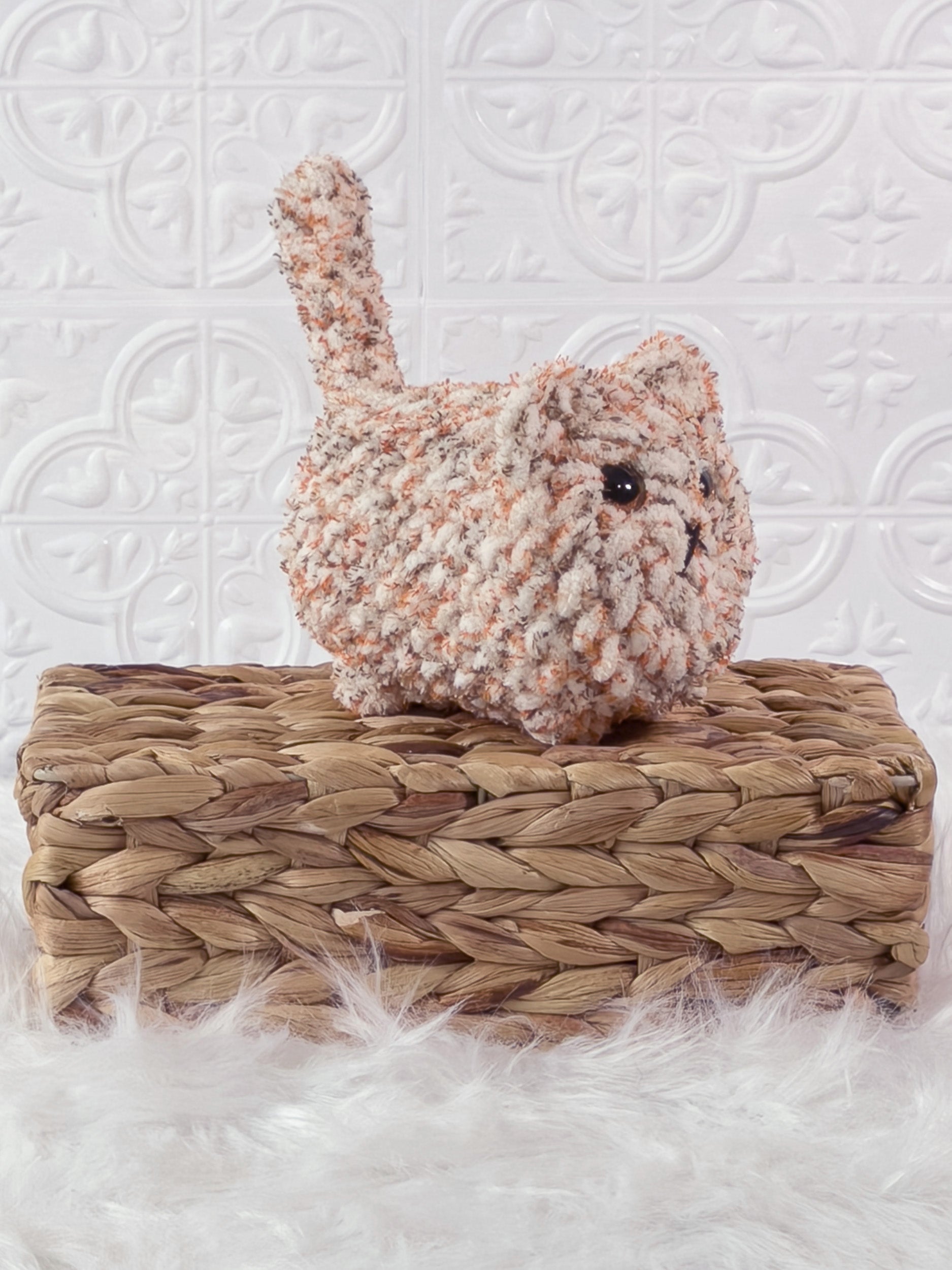 Handmade tweed, orange loaf cat crochet plushie shown from an angled view
