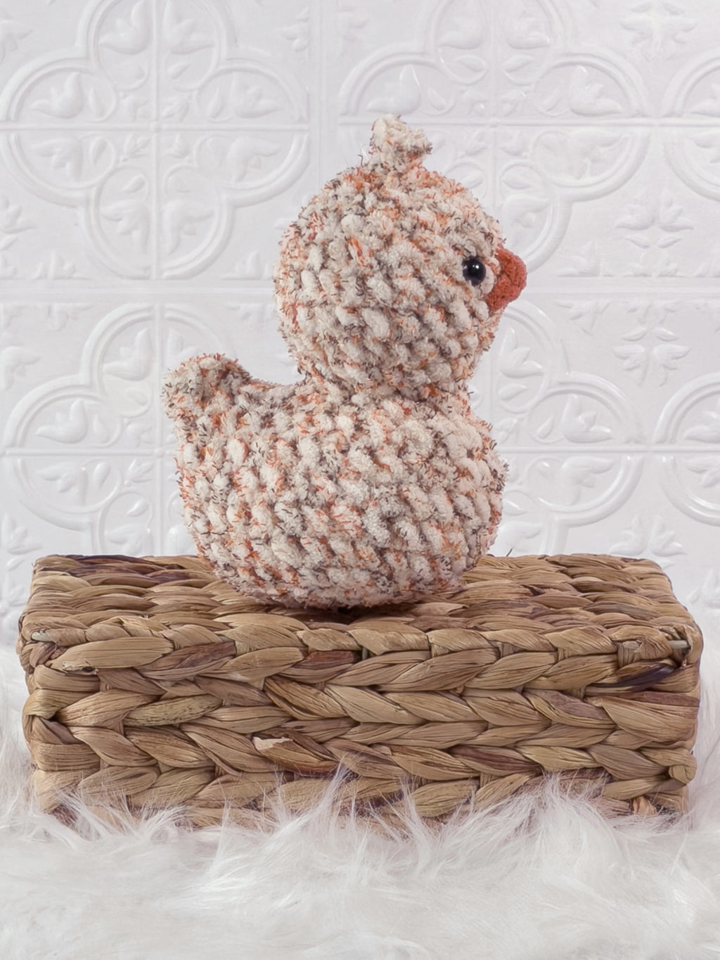 Handmade tweed, orange rubber duck crochet plushie shown from the side