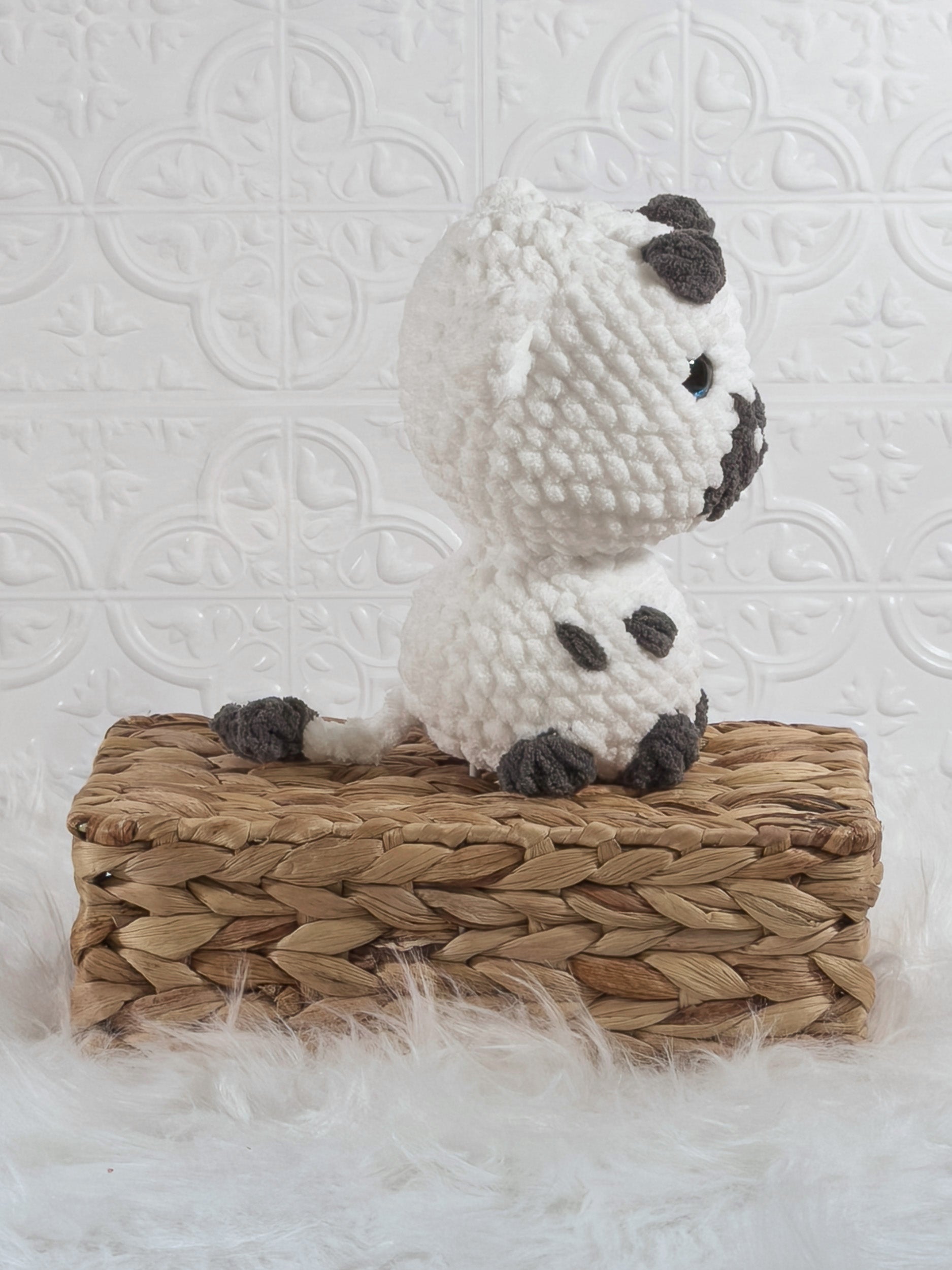 Handmade white cow crochet plushie shown from the side