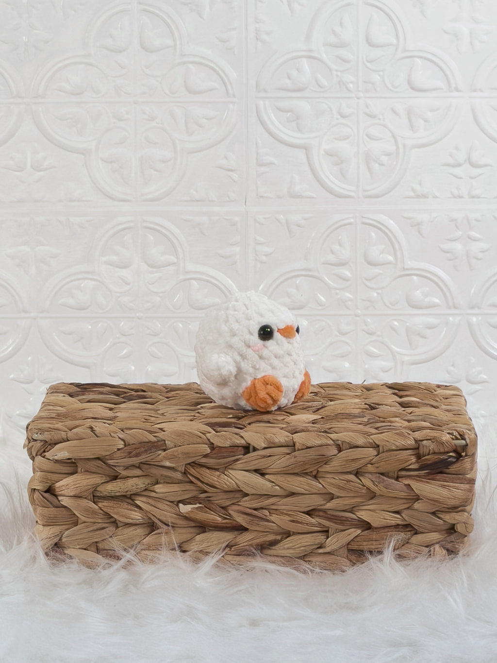 Handmade white, orange baby chick crochet plushie shown from an angled view