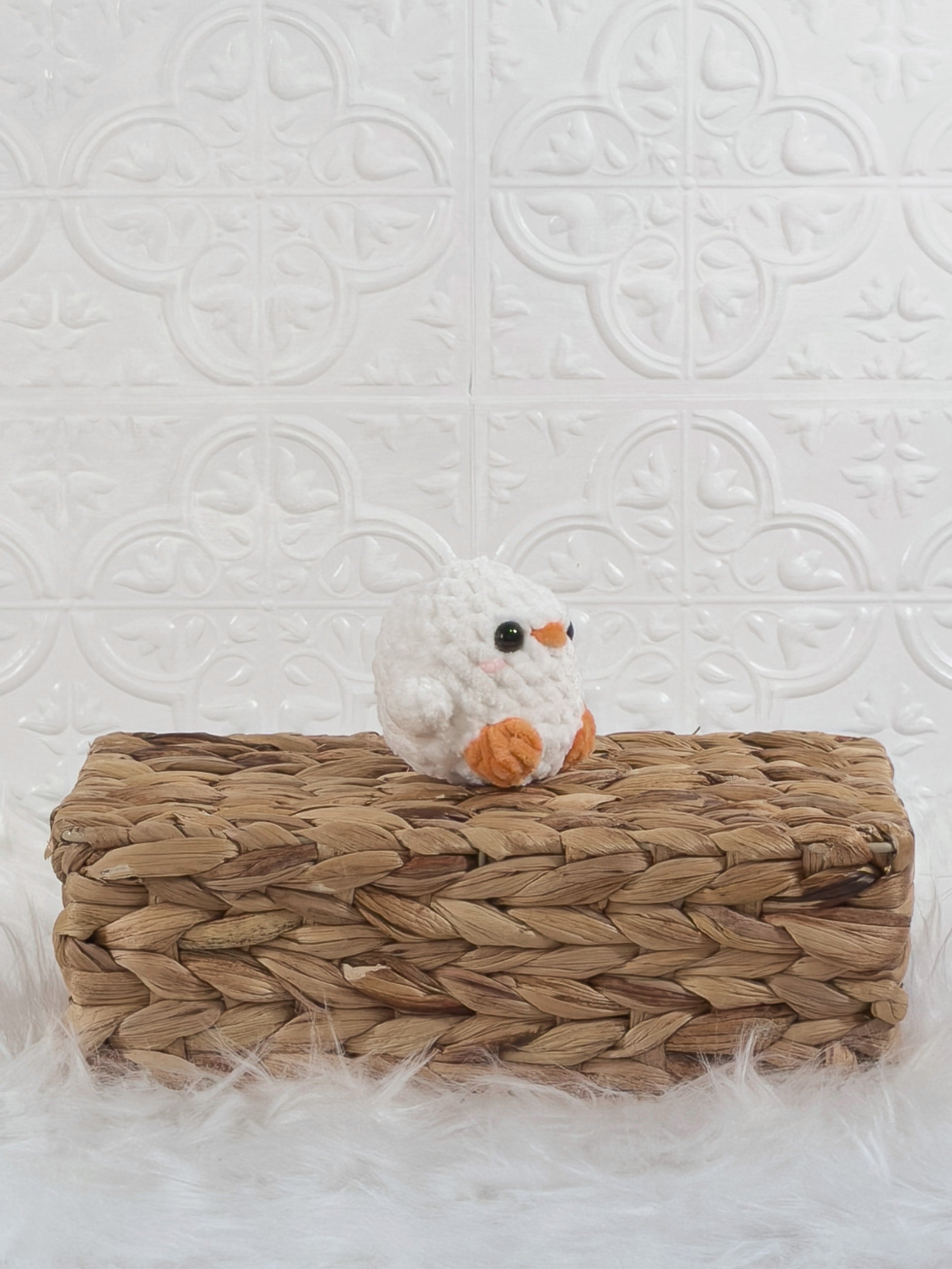 Handmade white, orange baby chick crochet plushie shown from an angled view