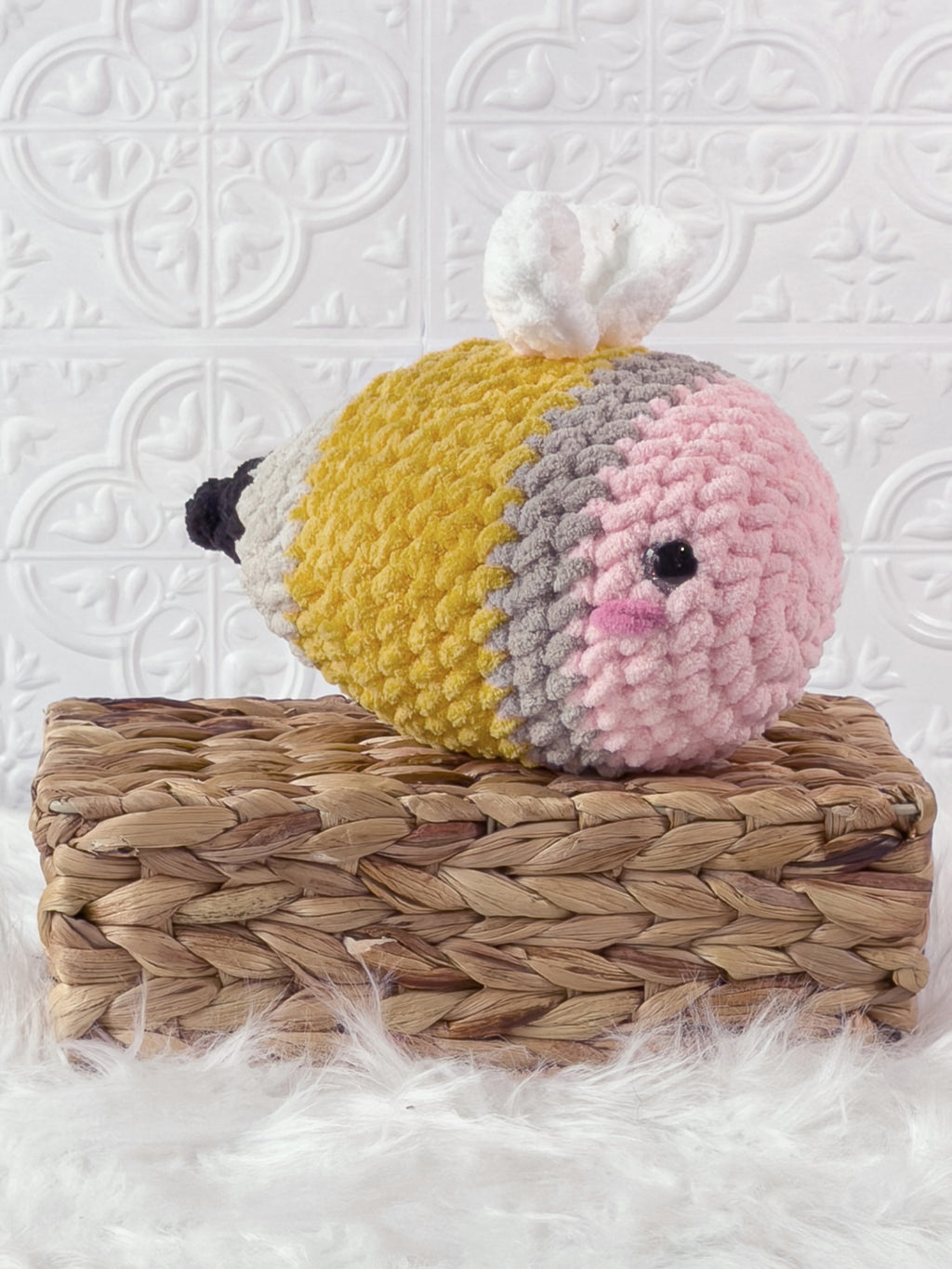 Handmade yellow bee pencil crochet plushie shown from an angled view