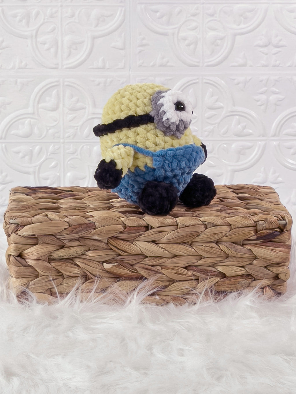 Handmade yellow minion crochet plushie shown from an angled view
