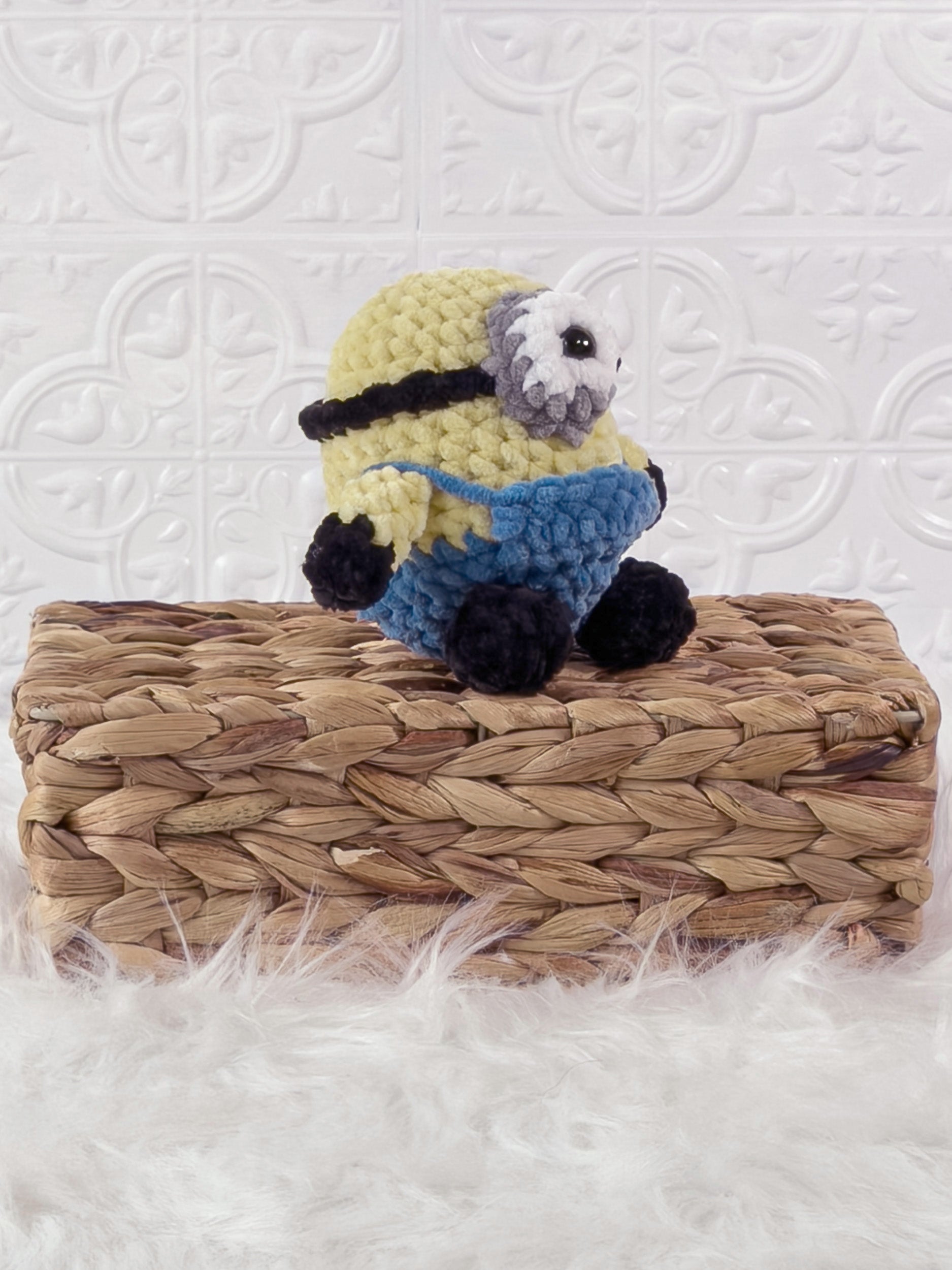 Handmade yellow minion crochet plushie shown from an angled view