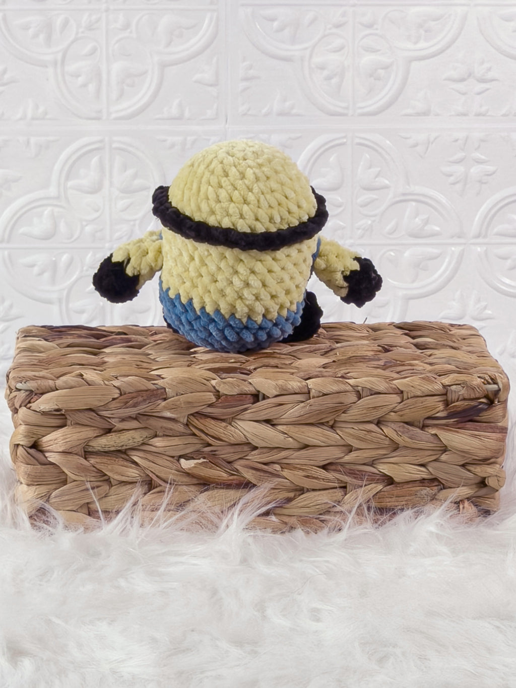 Handmade yellow minion crochet plushie shown from the back