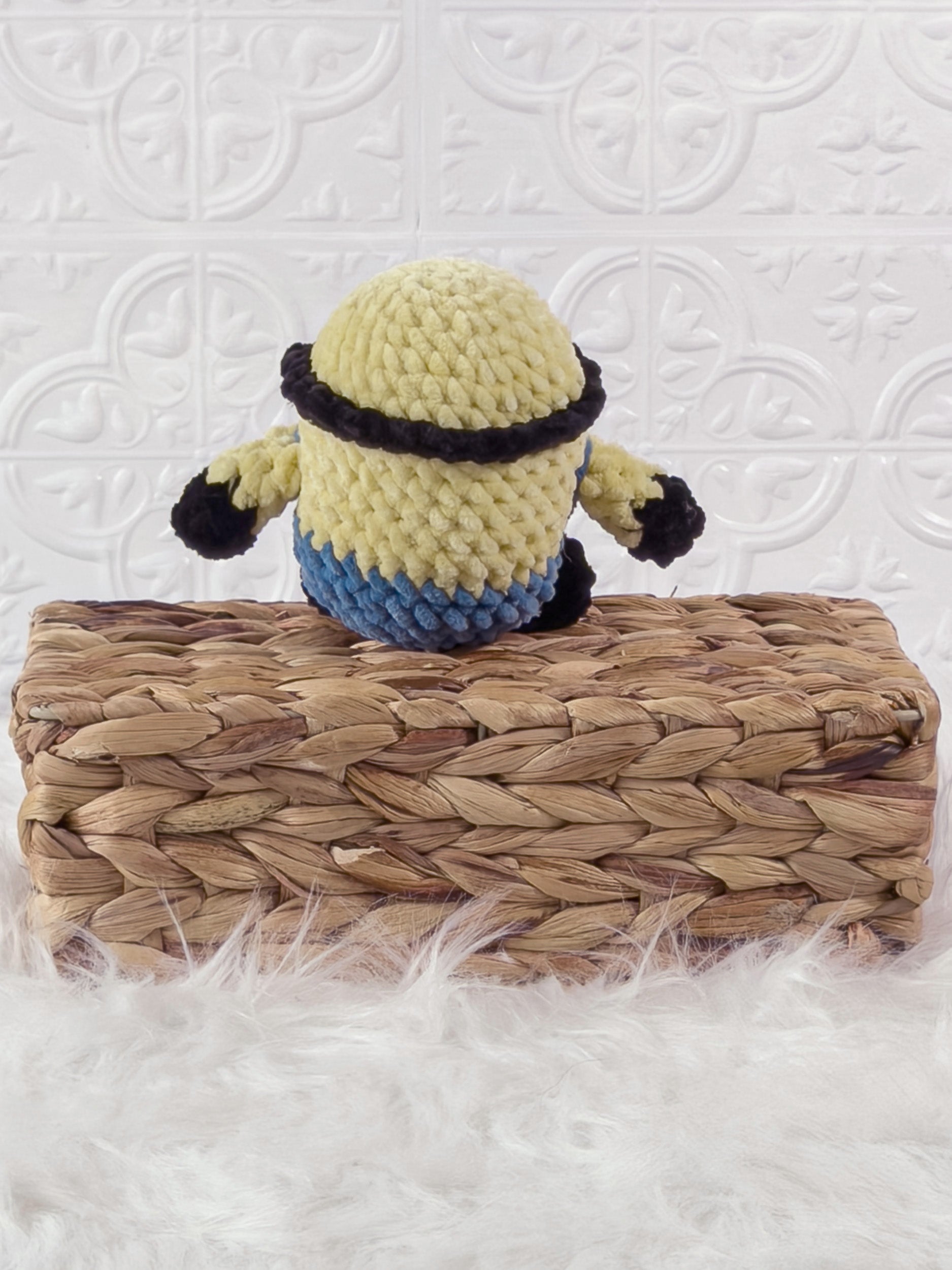 Handmade yellow minion crochet plushie shown from the back