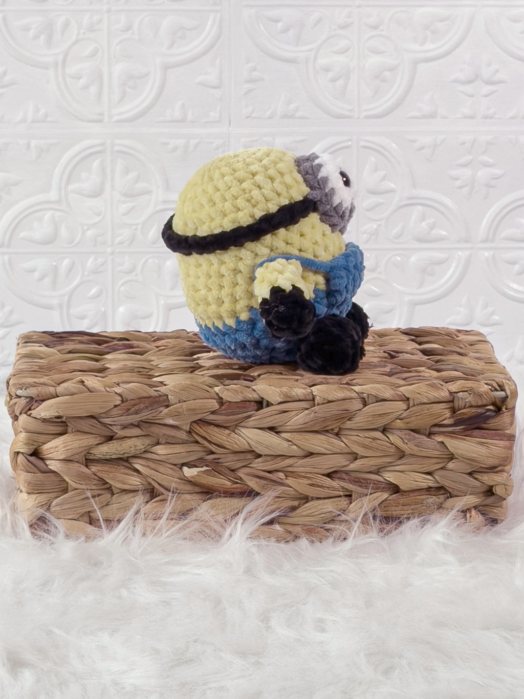 Handmade yellow minion crochet plushie shown from the side