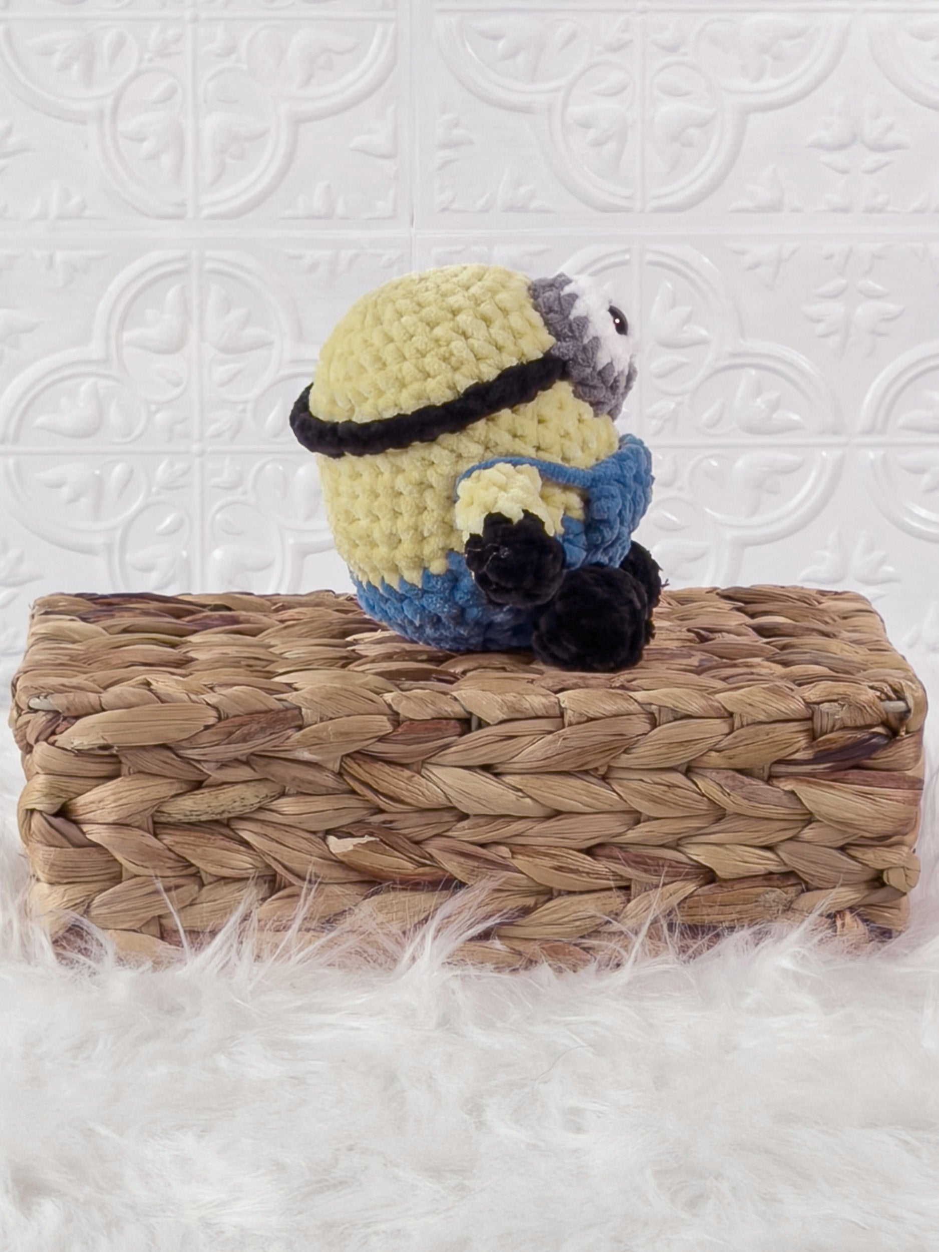 Handmade yellow minion crochet plushie shown from the side