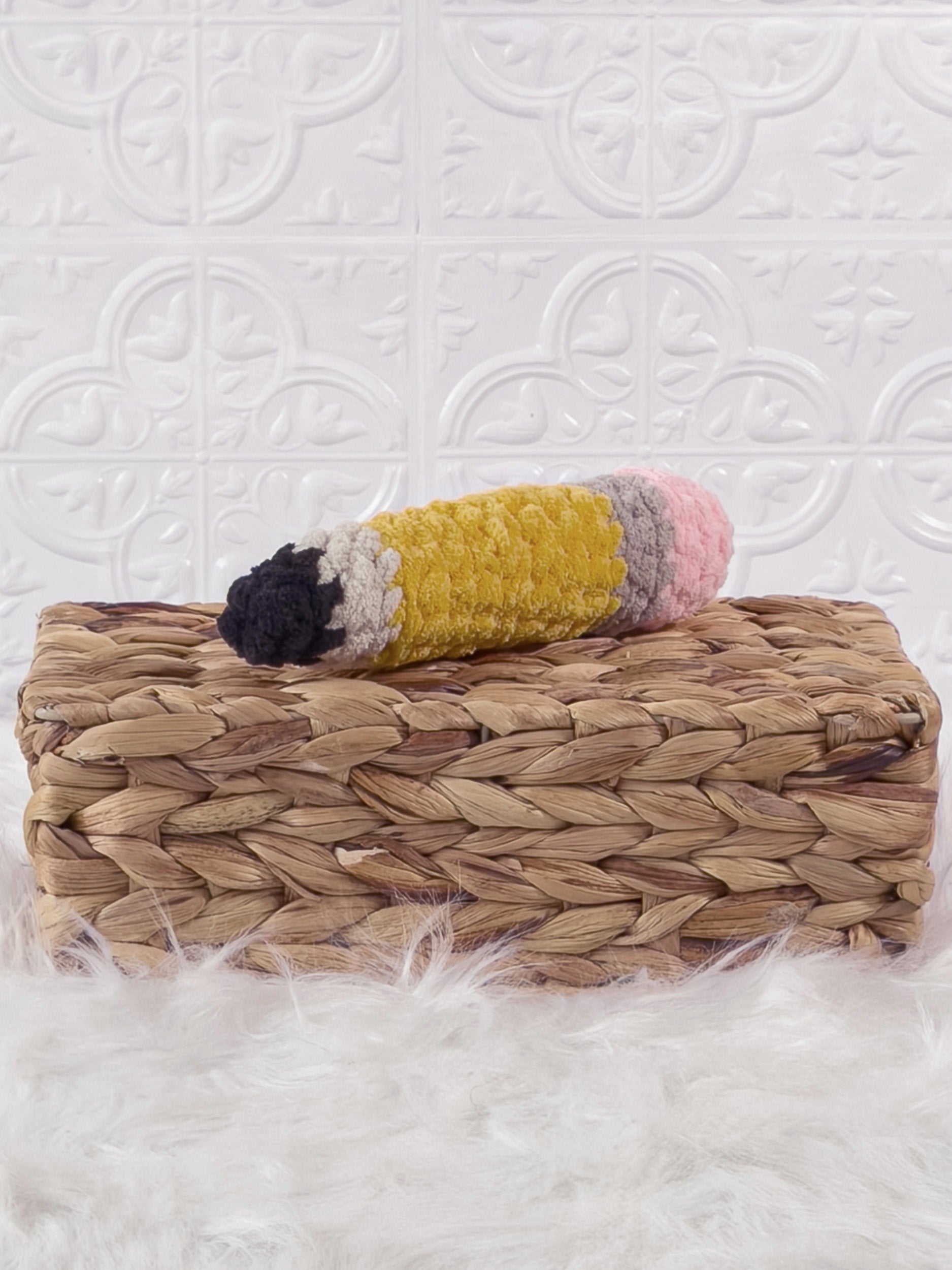 Handmade yellow pencil crochet plushie shown from an angled view