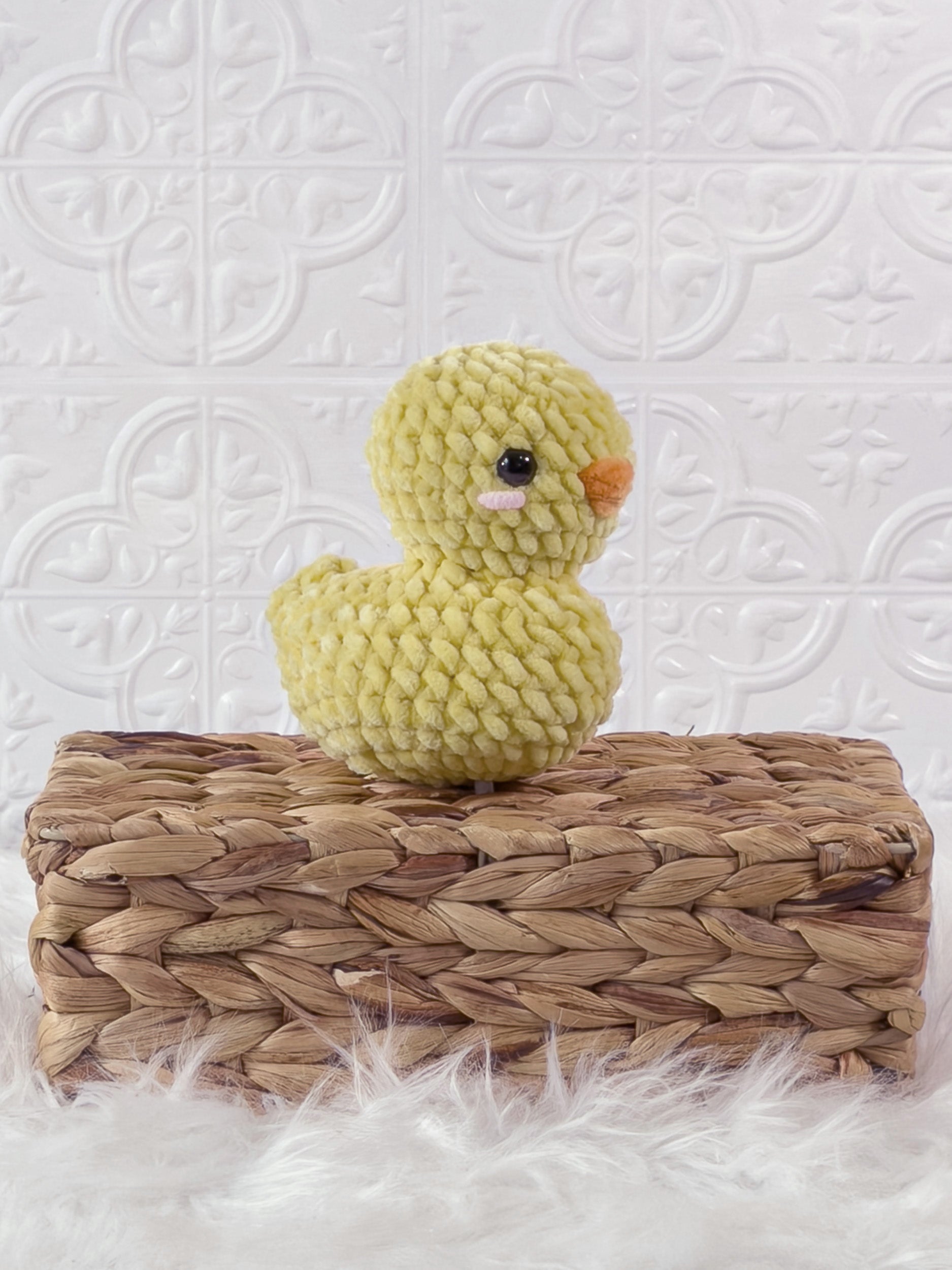 Handmade yellow rubber duck crochet plushie shown from an angled view