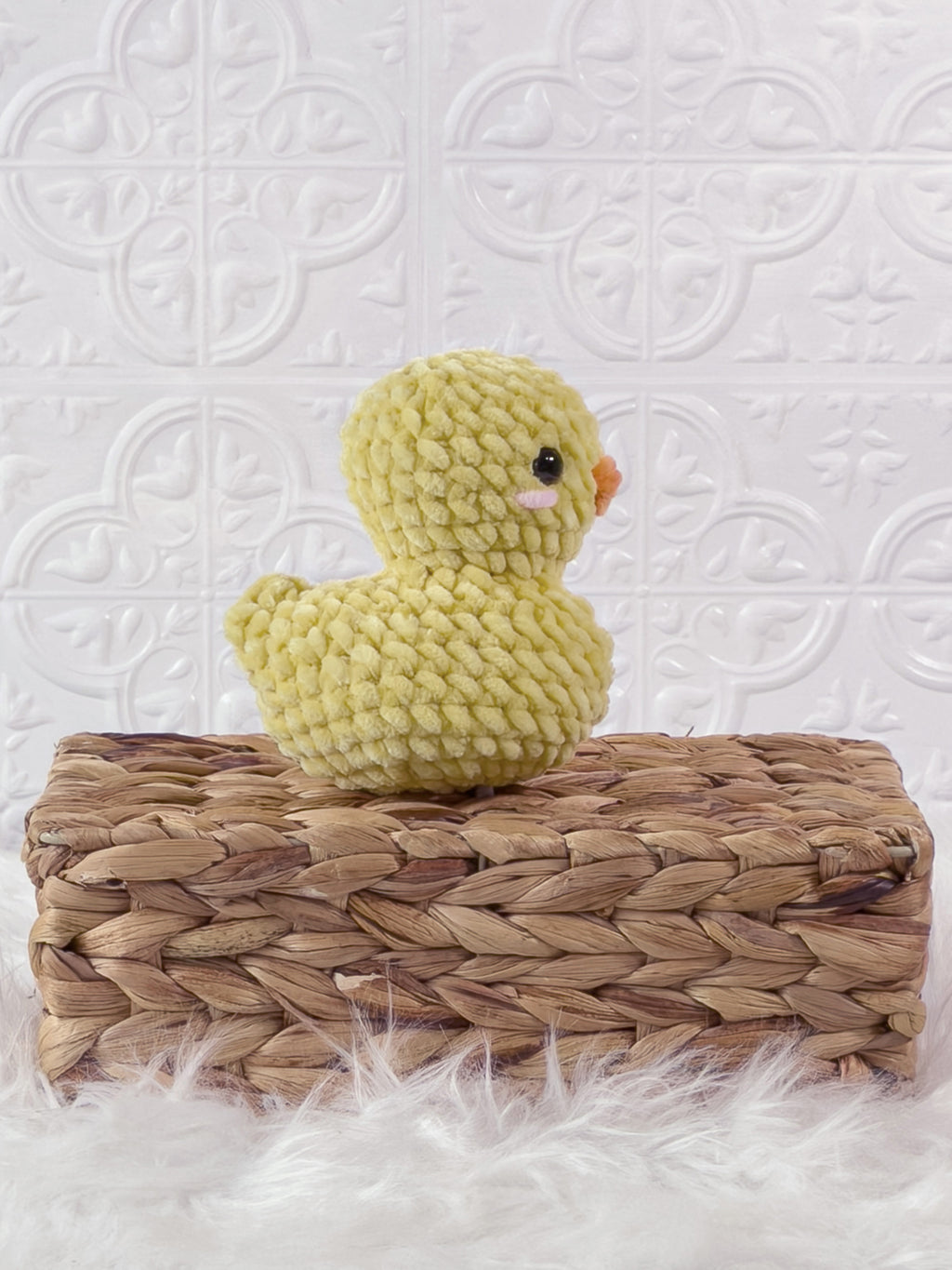 Handmade yellow rubber duck crochet plushie shown from the side