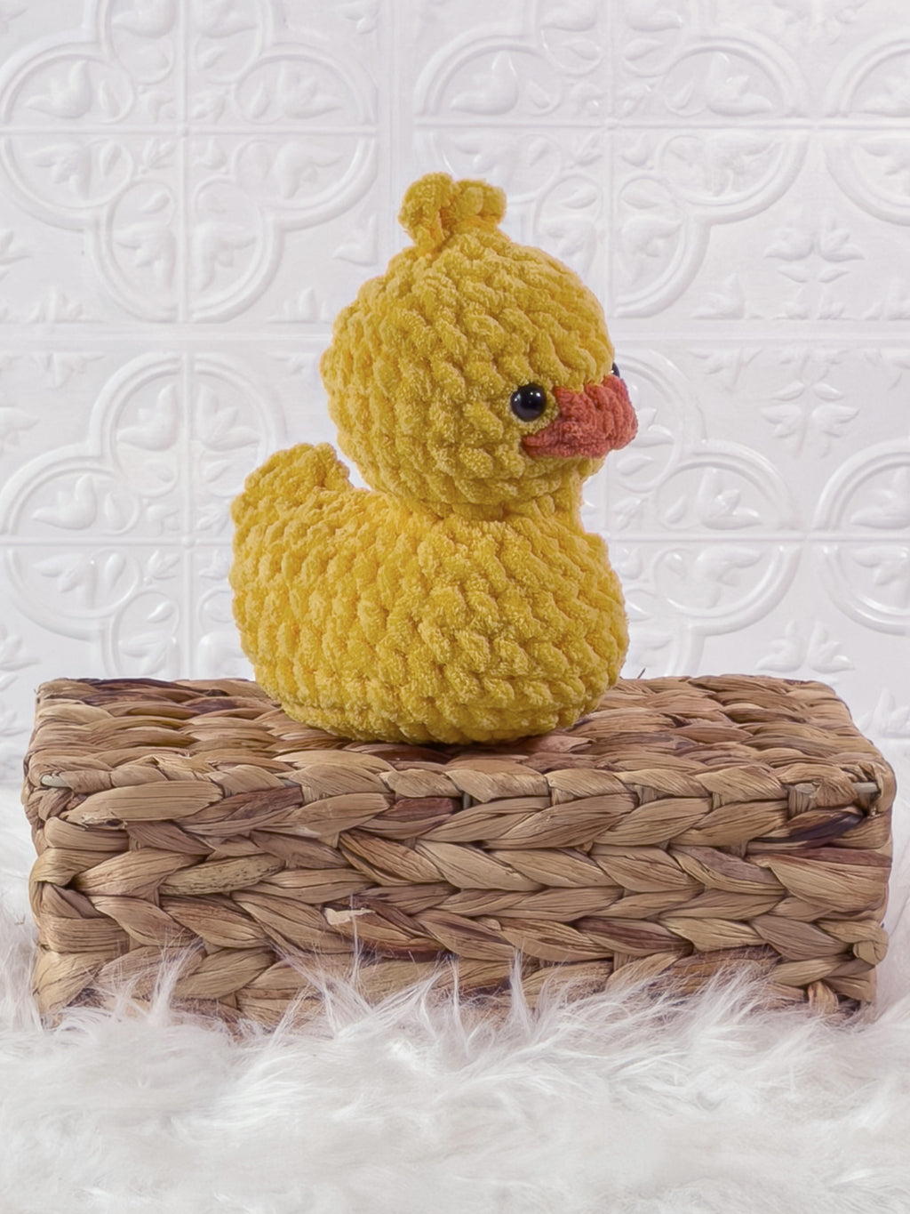 Handmade yellow, dark rubber duck crochet plushie shown from an angled view