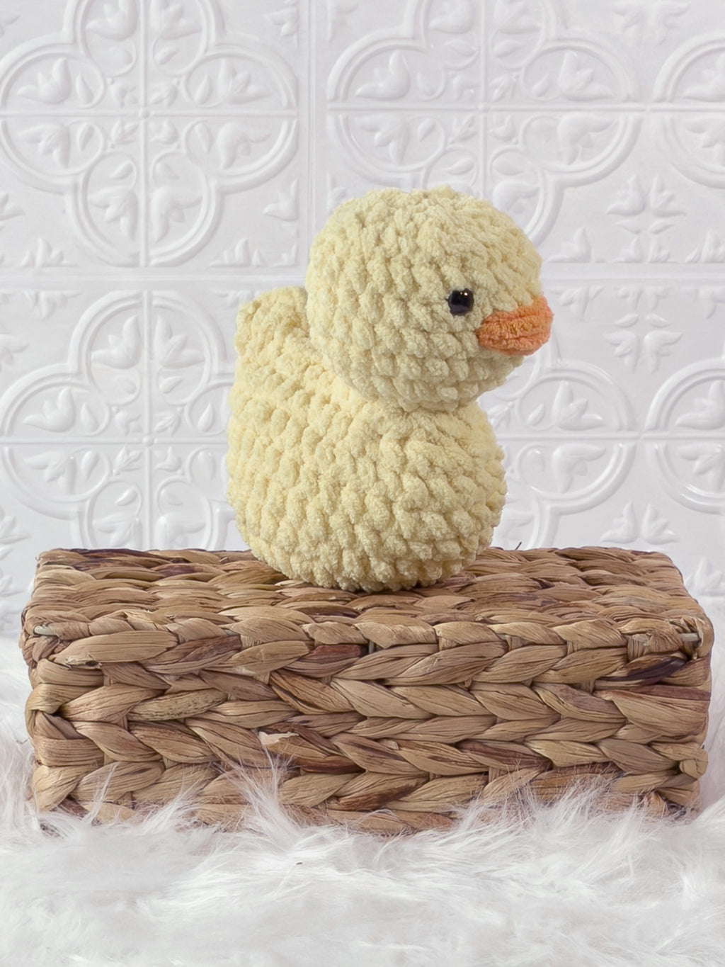 Handmade yellow, light rubber duck crochet plushie shown from an angled view
