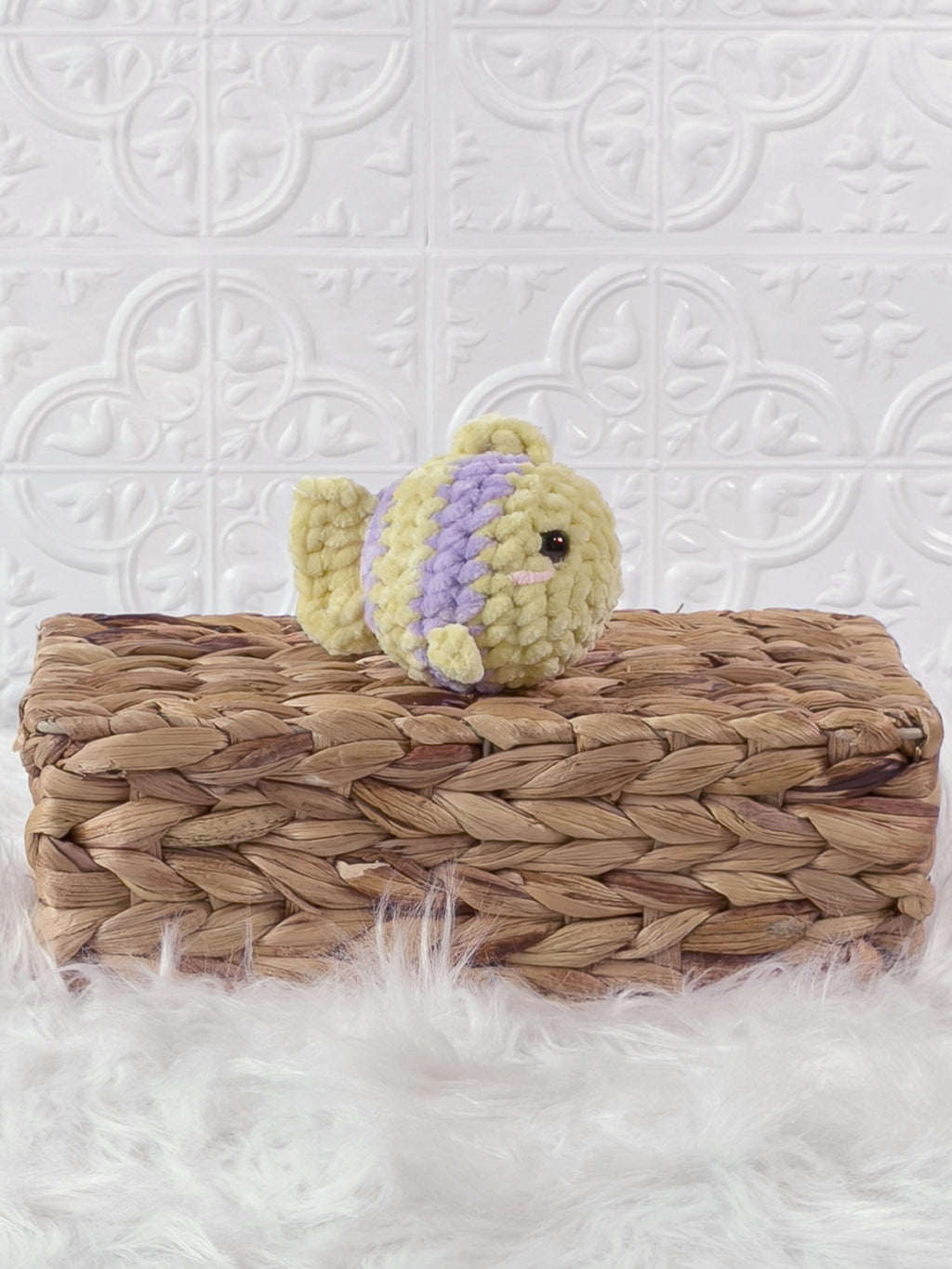 Handmade yellow, purple mini fish crochet plushie shown from an angled view
