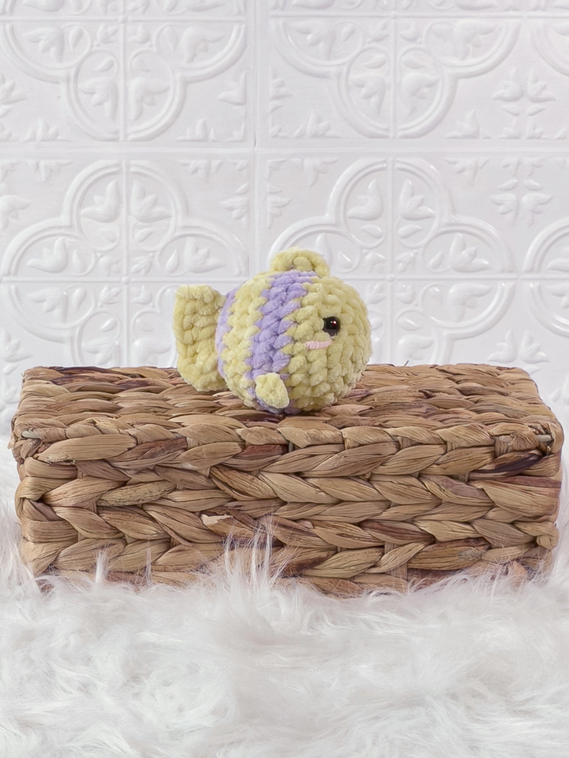 Handmade yellow, purple mini fish crochet plushie shown from an angled view