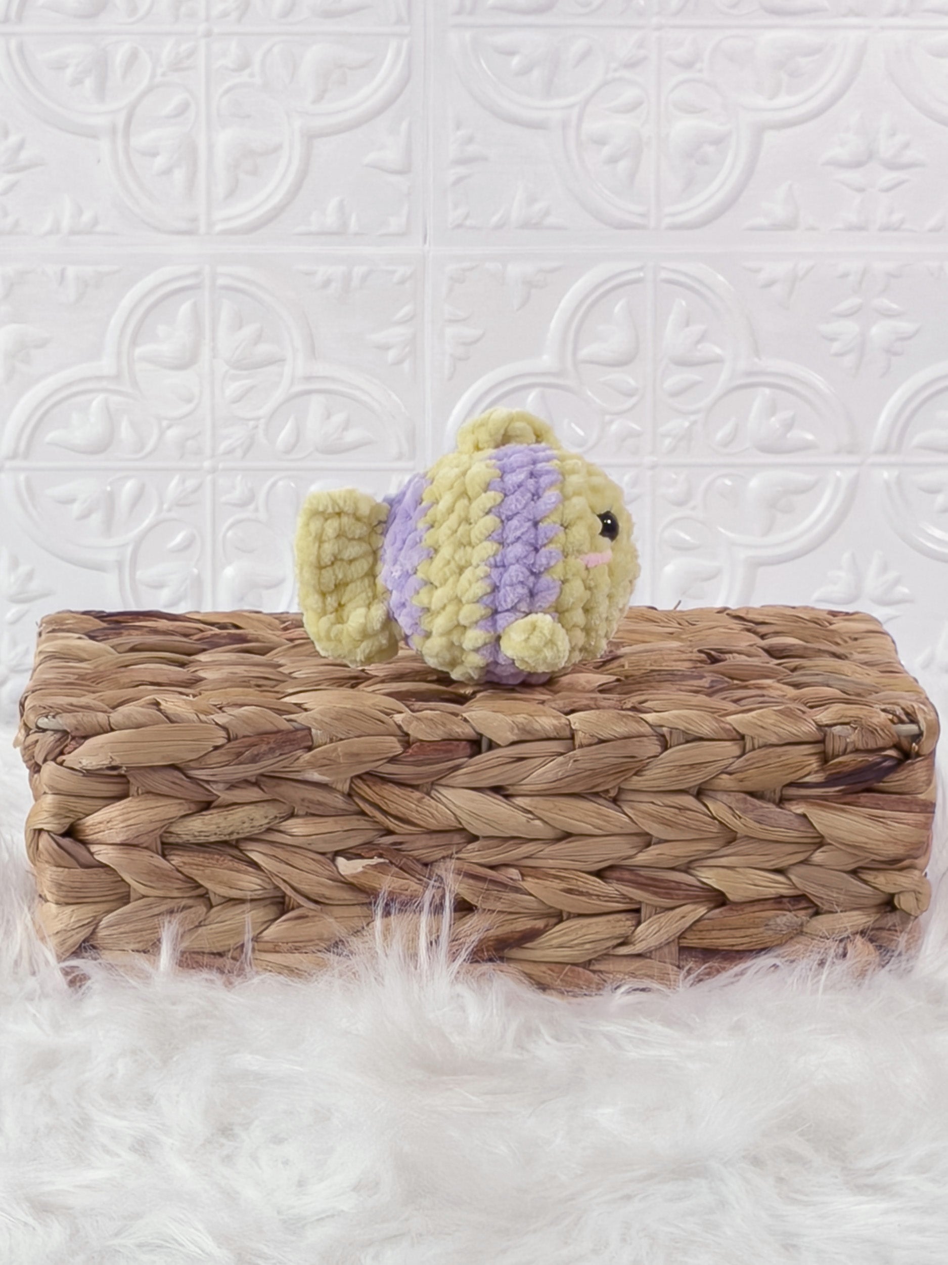 Handmade yellow, purple mini fish crochet plushie shown from the side